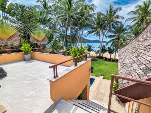 einen Balkon mit Blick auf das Meer und die Palmen in der Unterkunft Beachfront 5-bedroom Villa - by KohChangVillas in Ko Chang