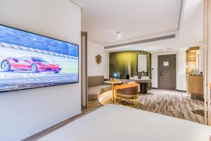 a hotel room with a large tv on the wall at Cozylife Hotel Canal in Hangzhou