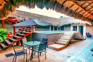 een terras met een tafel en stoelen en een zwembad bij Cielito 1 in Tulum