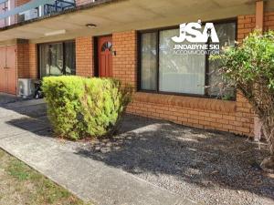 a building with a bush in front of it at Silvers 1 in Jindabyne