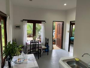 cocina con fregadero y comedor en Cozy jungle House 2BD Central located, en Ko Pha Ngan