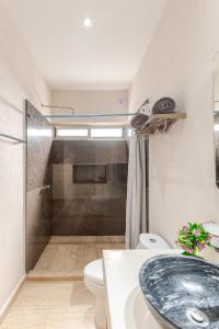 アクマルにあるDepartamento 3, Tulum Country Home, con Muelle de Pesca, Club de Playa, Alberca, Cenote y Campo de Golf, Contrata Day Pass Bahia Principeの洗面台、トイレ、シャワー付きのバスルーム