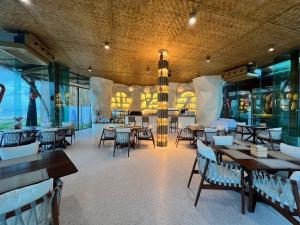 ein Restaurant mit Tischen und Stühlen in einem Raum in der Unterkunft Luxtalay Khanom Hotel in Khanom