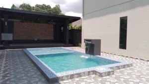 a swimming pool in a yard next to a building at D' Qamar Guesthouse in Kuantan