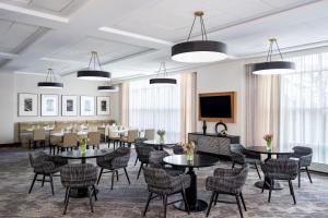 a dining room with tables and chairs and a flat screen tv at Sheraton Boston Needham Hotel in Needham