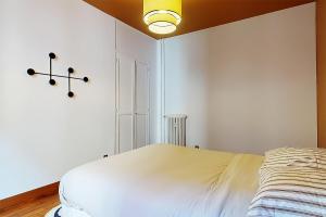 クリシーにあるL'écrin Havana , magnifique appartement hypercentreのベッドルーム1室(ベッド1台、壁に照明付)