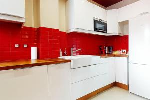 クリシーにあるL'écrin Havana , magnifique appartement hypercentreの赤い壁と白いキャビネット付きのキッチン +6枚の写真