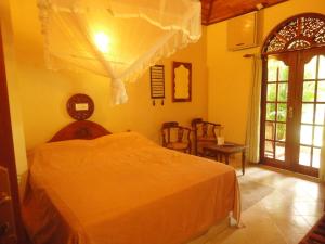 ein Schlafzimmer mit einem weißen Bett in einem Zimmer in der Unterkunft Dedduwa Boat House in Bentota