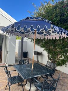 una mesa con una sombrilla azul en el patio en On Musson, en Hermanus