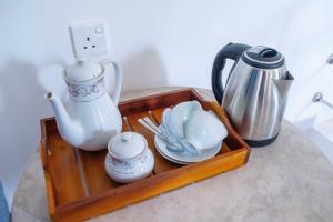 a wooden tray with a tea set and a tea kettle at AMA HomeStay in Udawalawe +27 photos