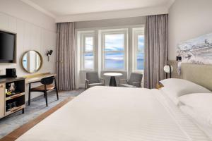 a hotel room with a large bed and a large window at Bournemouth Highcliff Marriott Hotel in Bournemouth