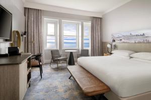 a hotel room with a bed and a table and chairs at Bournemouth Highcliff Marriott Hotel in Bournemouth
