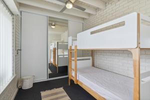 a room with bunk beds and a window at Views on Esplanade I Skate Ramp I Sleeps 12! in Seaford