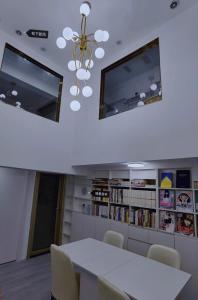a dining room with a white table and a chandelier at Cloud&Sea Inn in Shenzhen