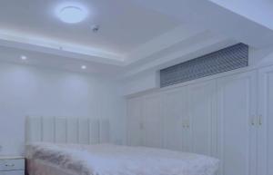 a white bedroom with a bed and a ceiling at Cloud&Sea Inn in Shenzhen