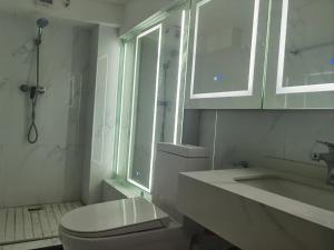 a bathroom with a toilet and a sink and a window at Cloud&Sea Inn in Shenzhen
