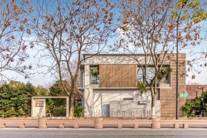 a house with a metal roof on the side of a street at Cozylife Hotel Canal in Hangzhou