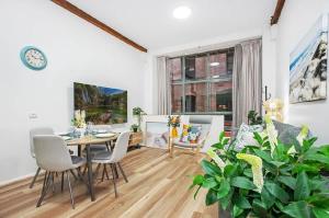 a living room with a table and chairs and a couch at Luxe suite in Darling Harbour with pool, sauna & gym - ICC 300m in Sydney