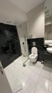 a bathroom with a toilet and a shower and a sink at Cozy Stylish Apartment الياسمين شمال الرياض in Riyadh +23 photos