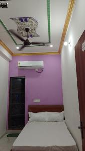 a room with a bed and a purple wall at Shri Krishnam Guest House Near Khatu Mandir in Khātu