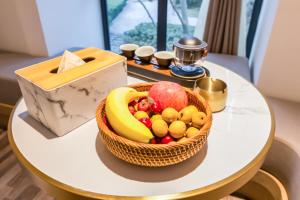a basket of fruit sitting on a table at Cozylife Hotel Canal in Hangzhou