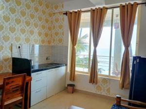 a kitchen with a window with a view of the ocean at GS Home on the Bay- Super Sea & Garden view Glass studio apartment in Vagator