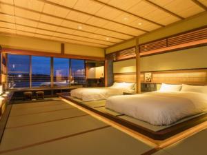 A bed or beds in a room at Kurofune Hotel