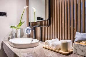 a bathroom with a sink and a mirror at Cozylife Hotel Canal in Hangzhou