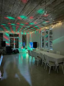 a room with a table and chairs and green lights at Rcheuli Villa in Charnali in Batumi