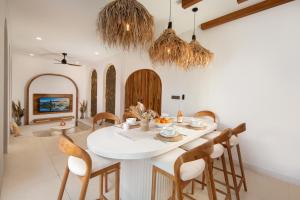 een eetkamer met een witte tafel en stoelen bij Casa Mana Ubud in Ubud