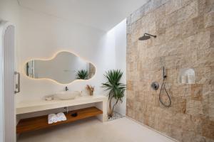 een badkamer met wastafel en douche met spiegel bij Casa Mana Ubud in Ubud
