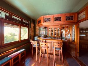 a kitchen with a bar with wooden cabinets and stools at Ridgeview Lodge in Durban