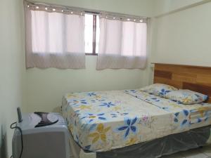 a bedroom with a bed and a desk and windows at Isabela´s Quality Accommodation in San Salvador