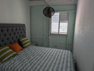 a bedroom with a bed and a clock on the wall at Habitaciones Casa Rural Tinina in Isla Saona
