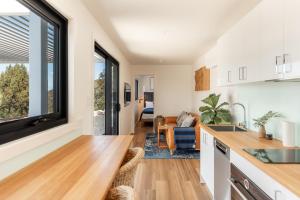 a kitchen with a large window and a living room at Bracken Retreat - Hobart in Brighton