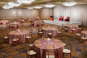 タウソンにあるSheraton Baltimore Northの紫のテーブルクロスが敷かれたテーブルと椅子が置かれた宴会場