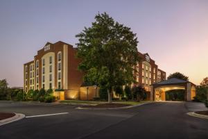 Four Points by Sheraton Greensboro Airport في جرينسبورو: مبنى به شجرة في منتصف الشارع