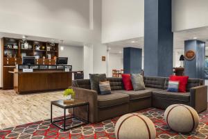 Four Points by Sheraton Greensboro Airport في جرينسبورو: غرفة معيشة مع أريكة وطاولة