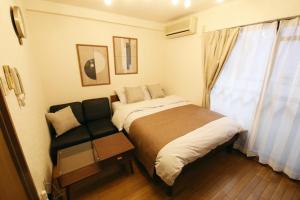 a small bedroom with a bed and a chair at 大井町アパートメントホテル豊強ビル in Tokyo