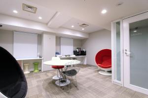 una camera con tavolo e sedia rossa di KOKO HOTEL Ginza-1chome a Tokyo