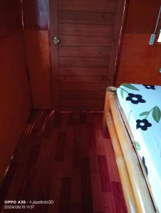 a small room with a bed and a wooden floor at Lucia's Native House in Lalao