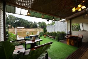 a patio with green grass and a table and chairs at Mata villa มาตา วิลล่า in Chiang Mai