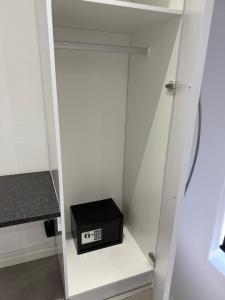 un armadio bianco con una scatola nera su uno scaffale di The Zebra a Gqeberha Altre 12 foto