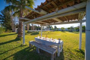 a picnic table under a pergola with a table at Villa Assunta With Pool Near The Sea - Happy Rentals in Melendugno +22 photos
