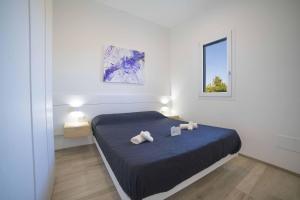 a bedroom with a bed with two towels on it at Villa Assunta With Pool Near The Sea - Happy Rentals in Melendugno