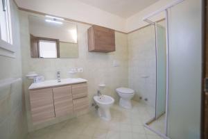 a bathroom with a toilet and a sink and a shower at Villa Assunta With Pool Near The Sea - Happy Rentals in Melendugno