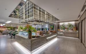 un ristorante con un bancone con delle piante di HOTEL CHAM CHAM - Taipei a Taipei