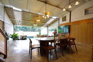 a dining room with a wooden table and chairs at Mata villa มาตา วิลล่า in Chiang Mai