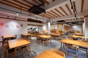 an empty restaurant with wooden tables and chairs at KKR Suwakoso in Suwa