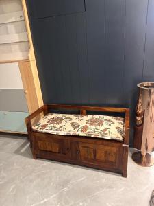 a wooden bed sitting in the corner of a room at AR Farms in Auroville